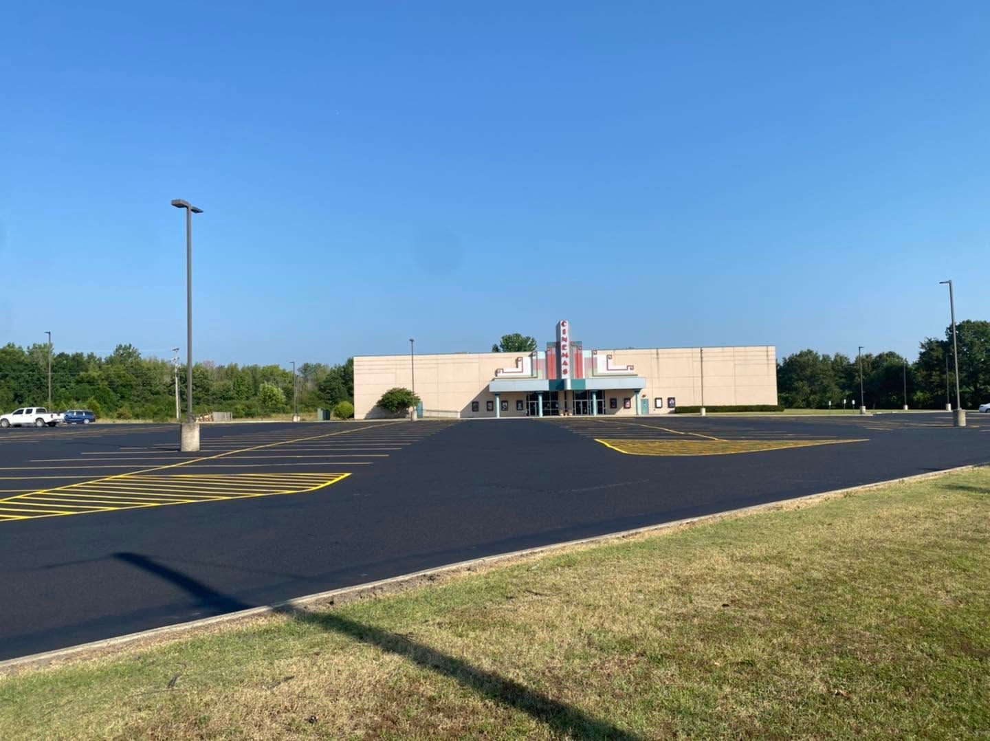 Empty parking lot in front of a beige building under a clear blue sky