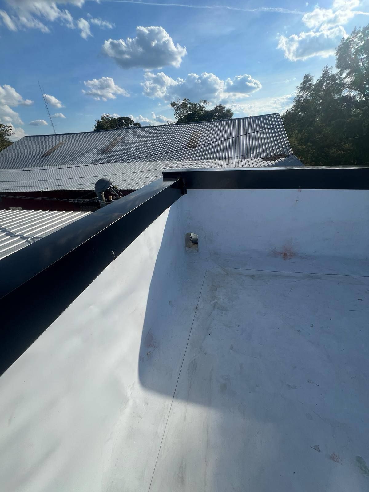 White roof with black trim and a bright blue sky.