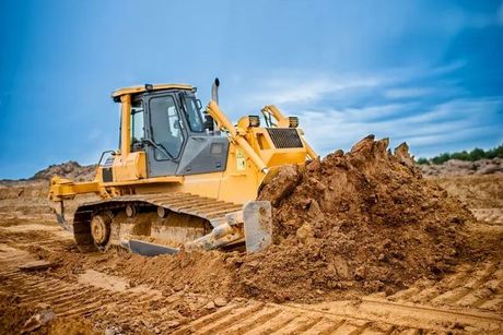 a bulldozer is moving dirt on a construction site 
