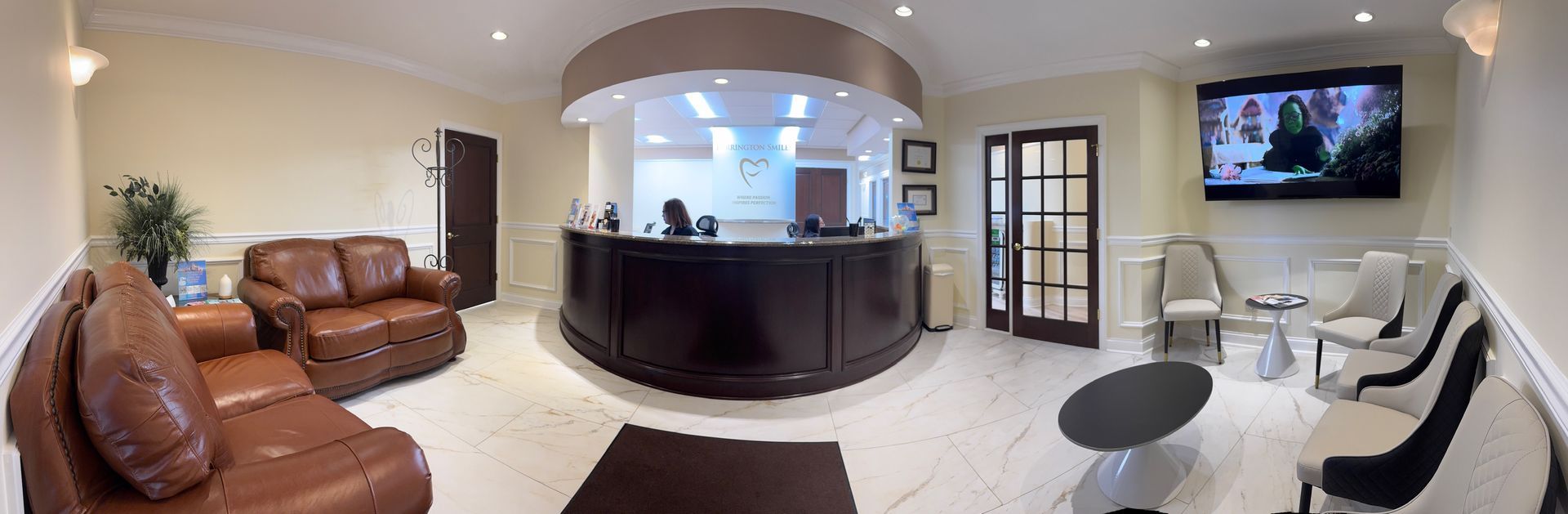 A large lobby with a round reception desk and a couch.