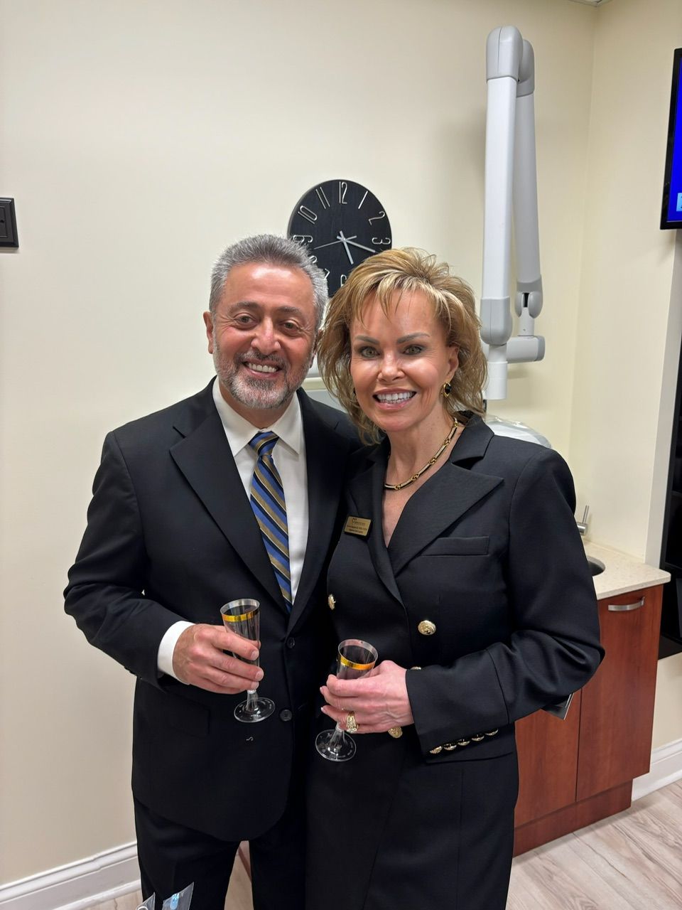 A man and a woman are posing for a picture while holding champagne glasses.