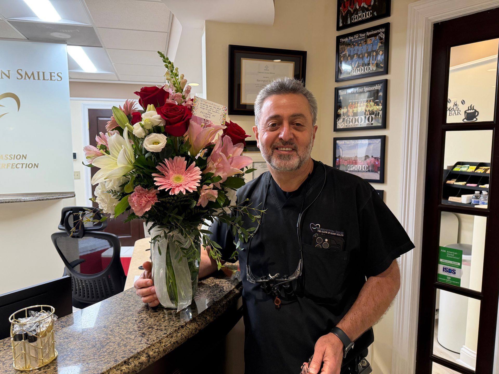 A man is holding a vase of flowers in a dental office.