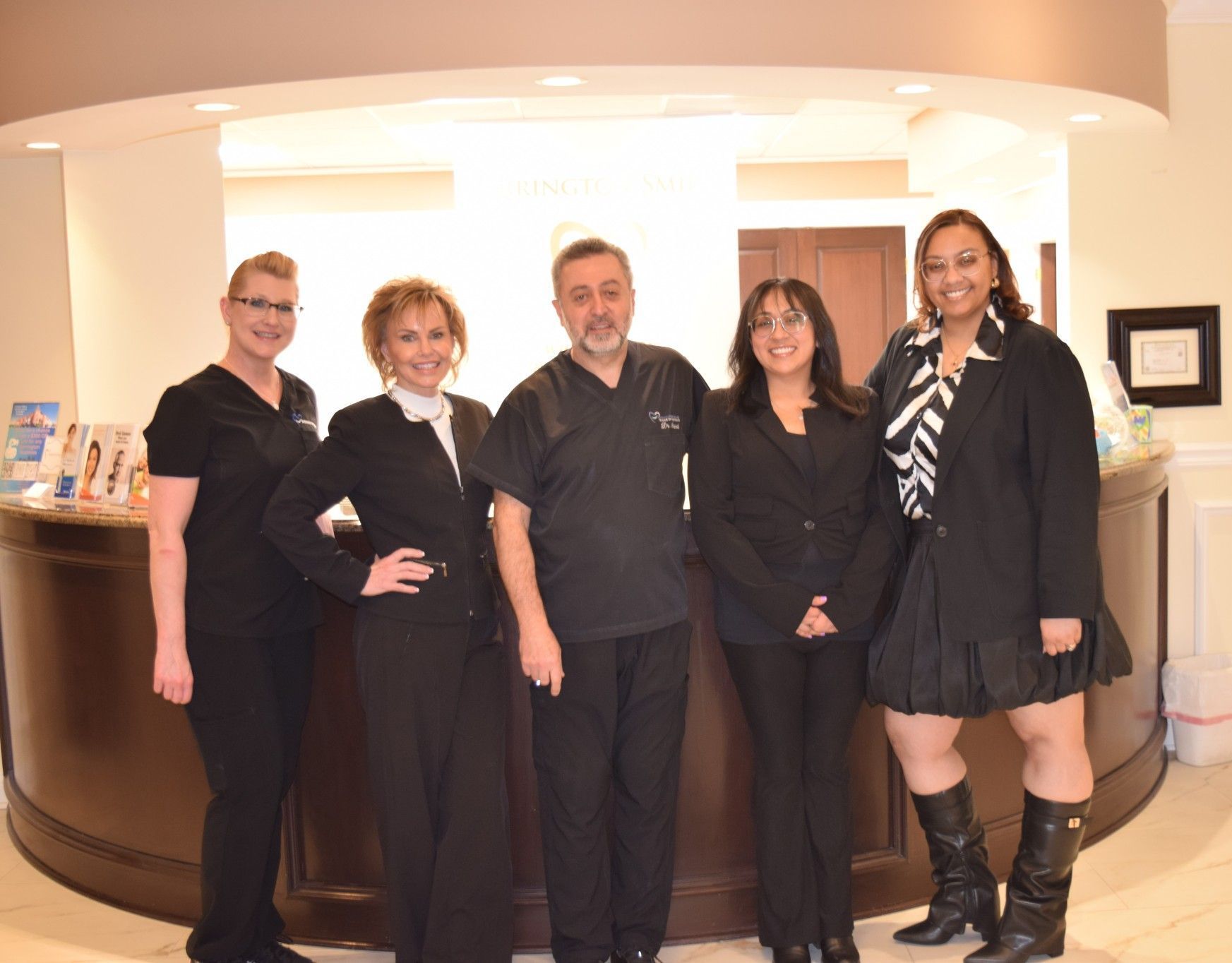 A group of people are posing for a picture in front of a counter.