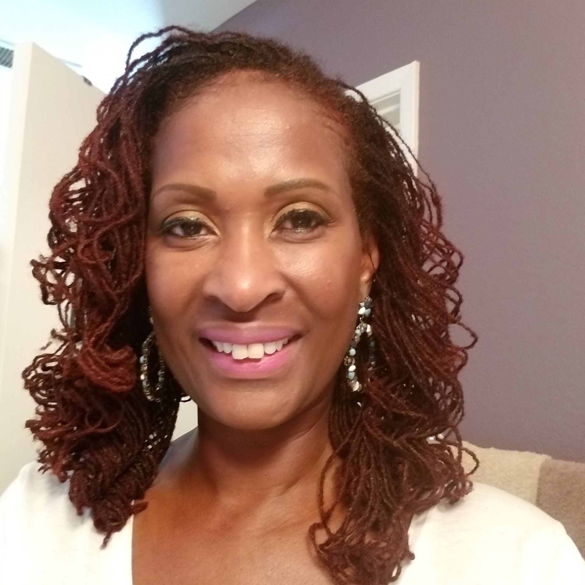 A woman with dreadlocks is smiling for the camera