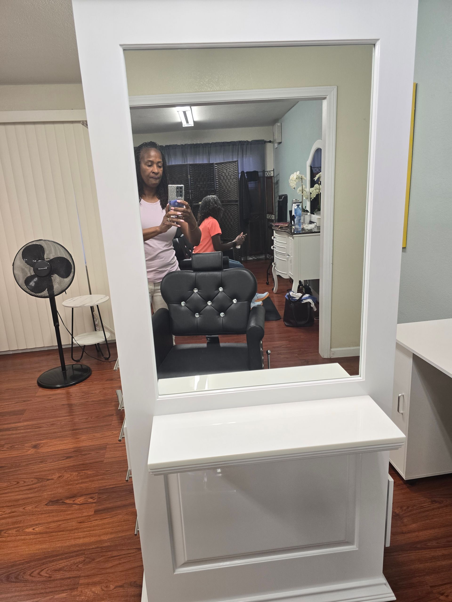 A woman is taking a picture of herself in a mirror in a salon