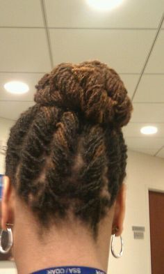 The back of a woman 's head with a bun and earrings