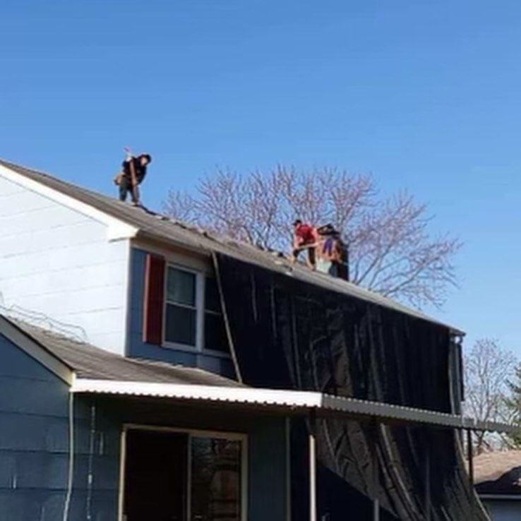 A group of people are working on the roof of a house