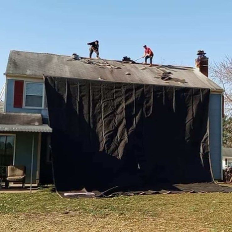 Two men are working on the roof of a house