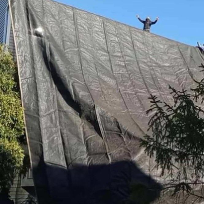 A man is standing on top of a large tarp