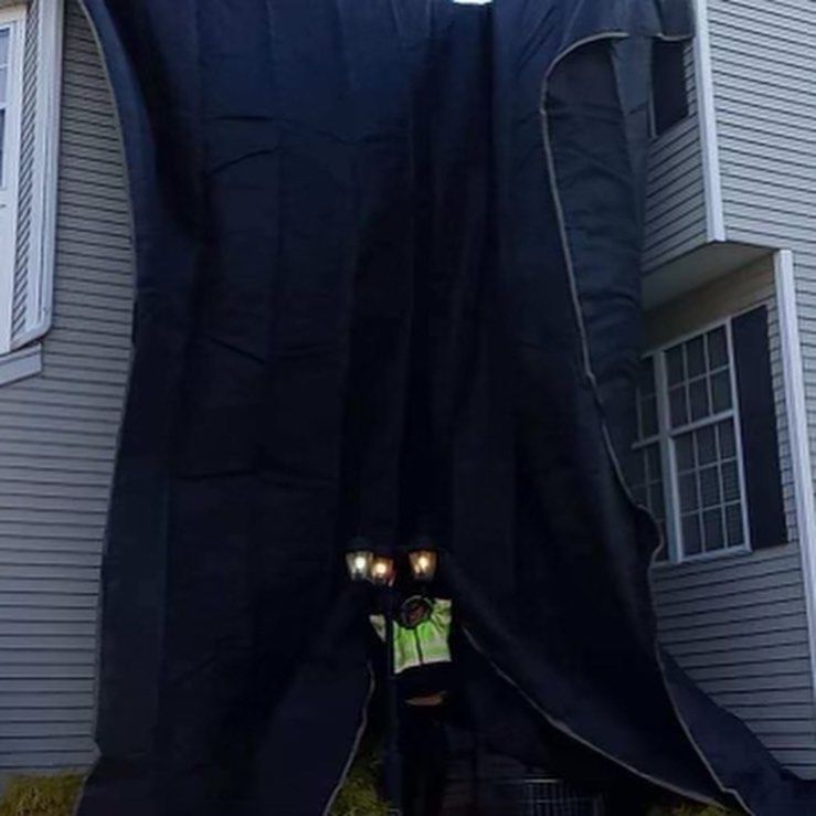A large black curtain is hanging from the side of a house