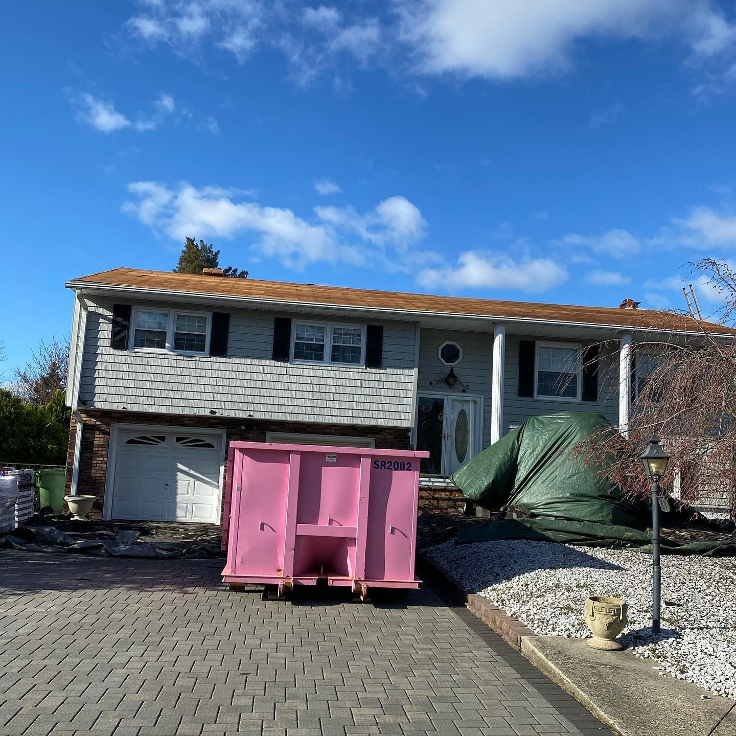 A house with a pink dumpster in front of it