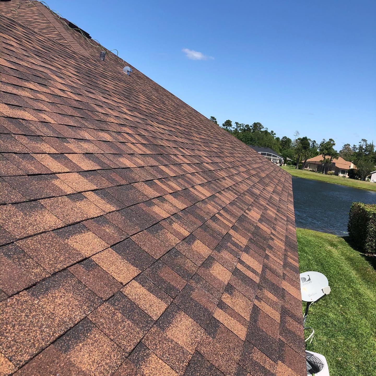 A roof with a lot of shingles is sitting next to a body of water