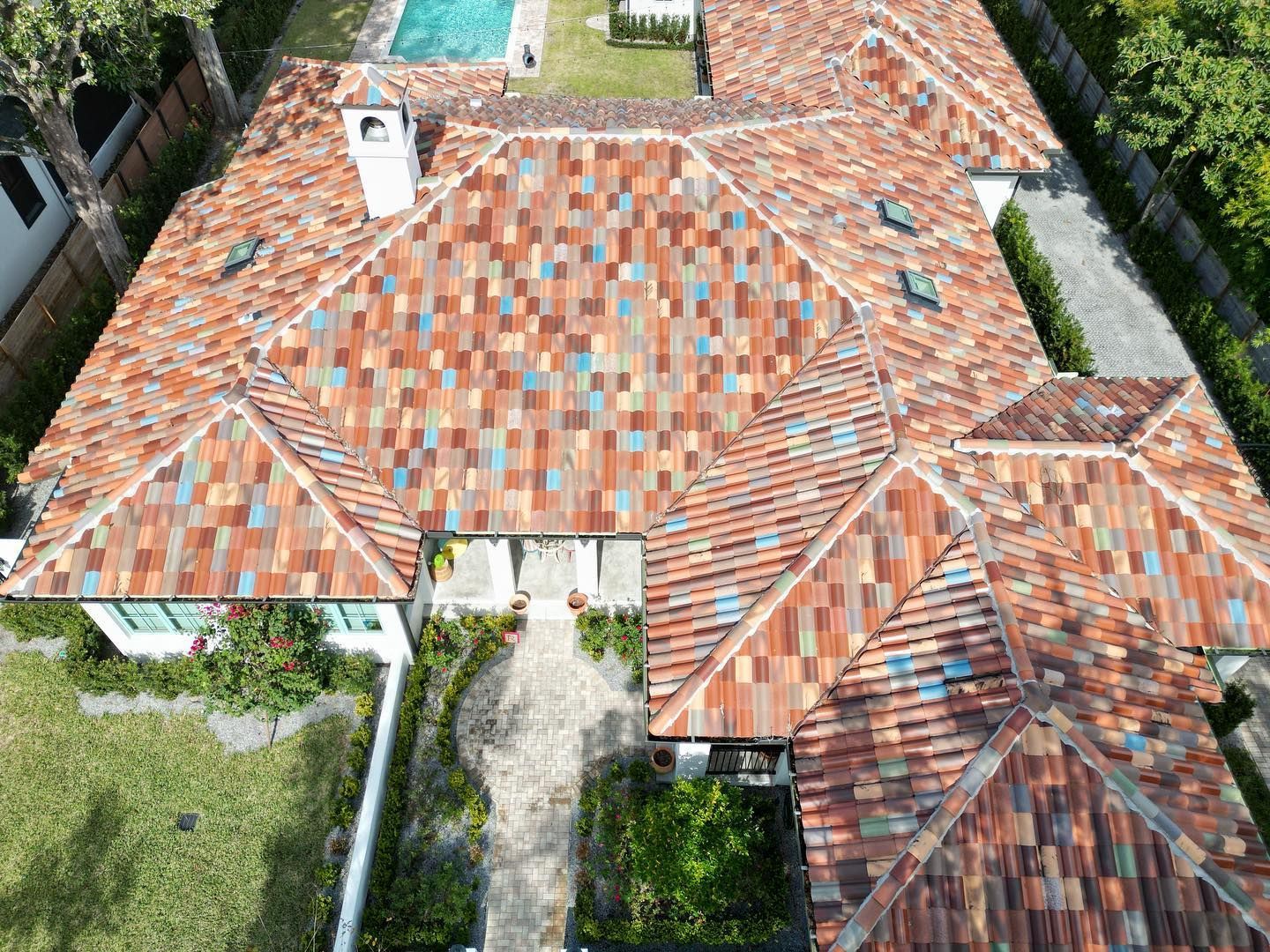An aerial view of a house with a tiled roof and a pool