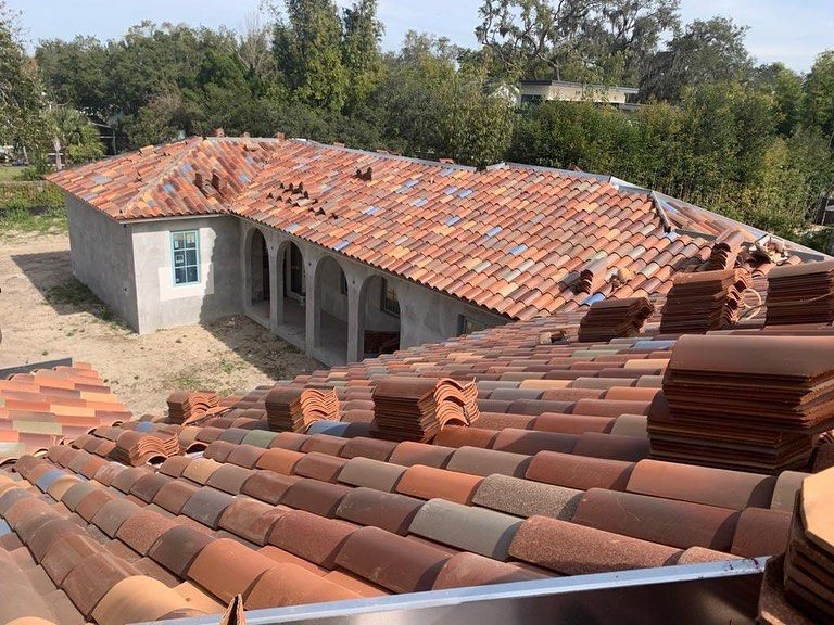 A roof with a lot of tiles on it and a house in the background