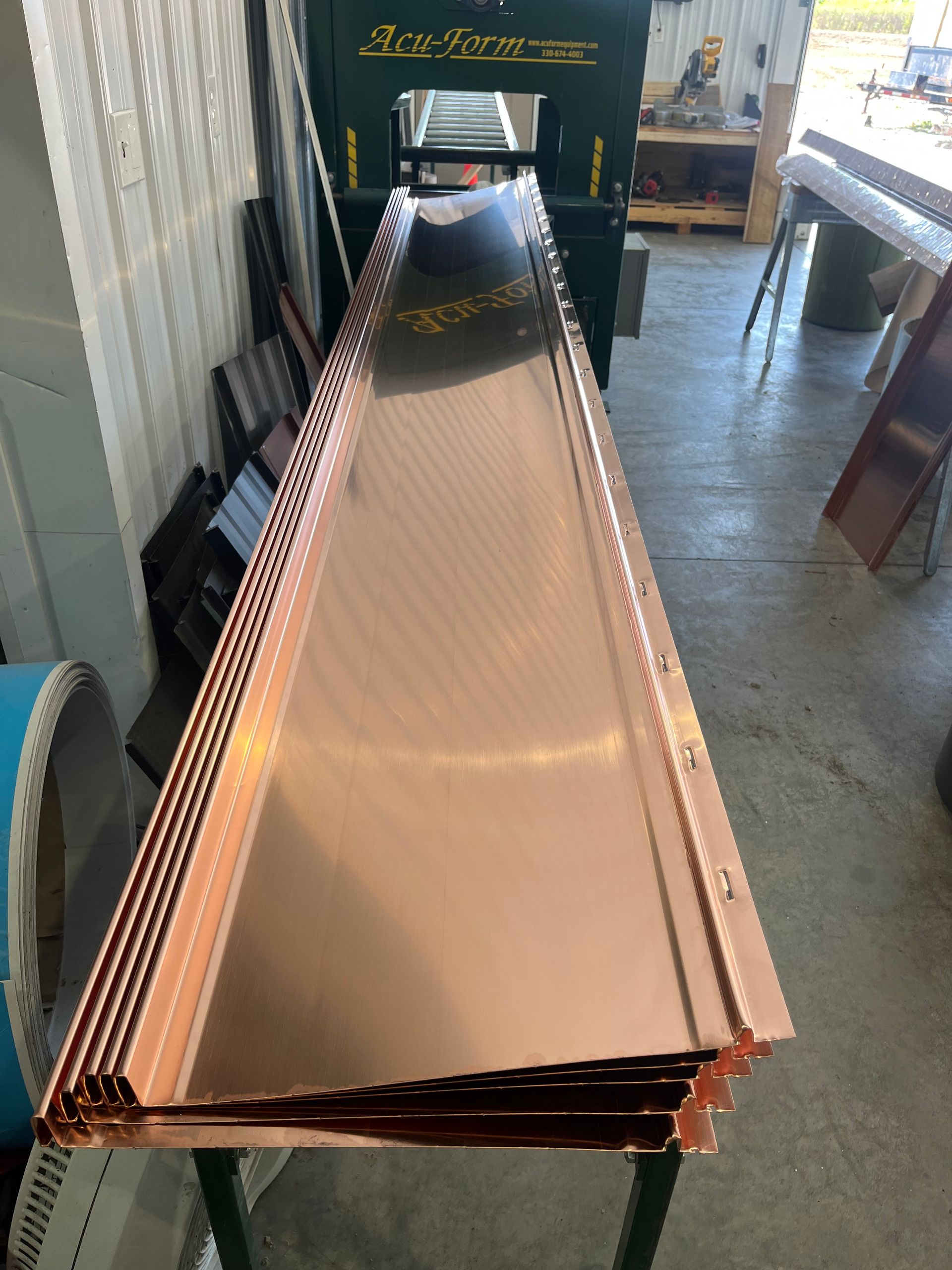 Long metal gutter-like trough with copper edges in a workshop or showroom