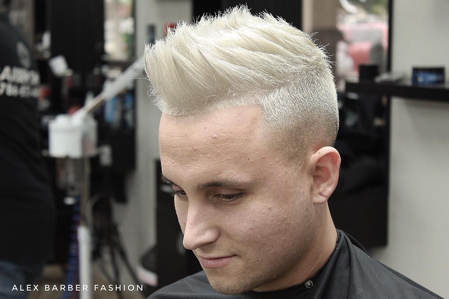 A man with white hair is getting his hair cut at a barber shop.
