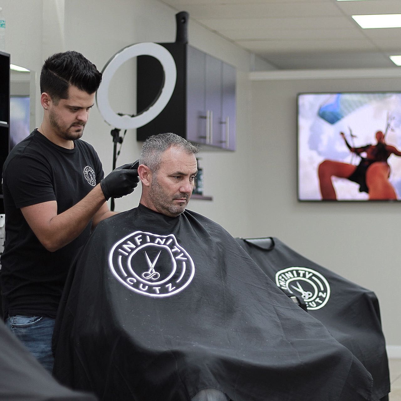 A man is getting his hair cut at infinity cut