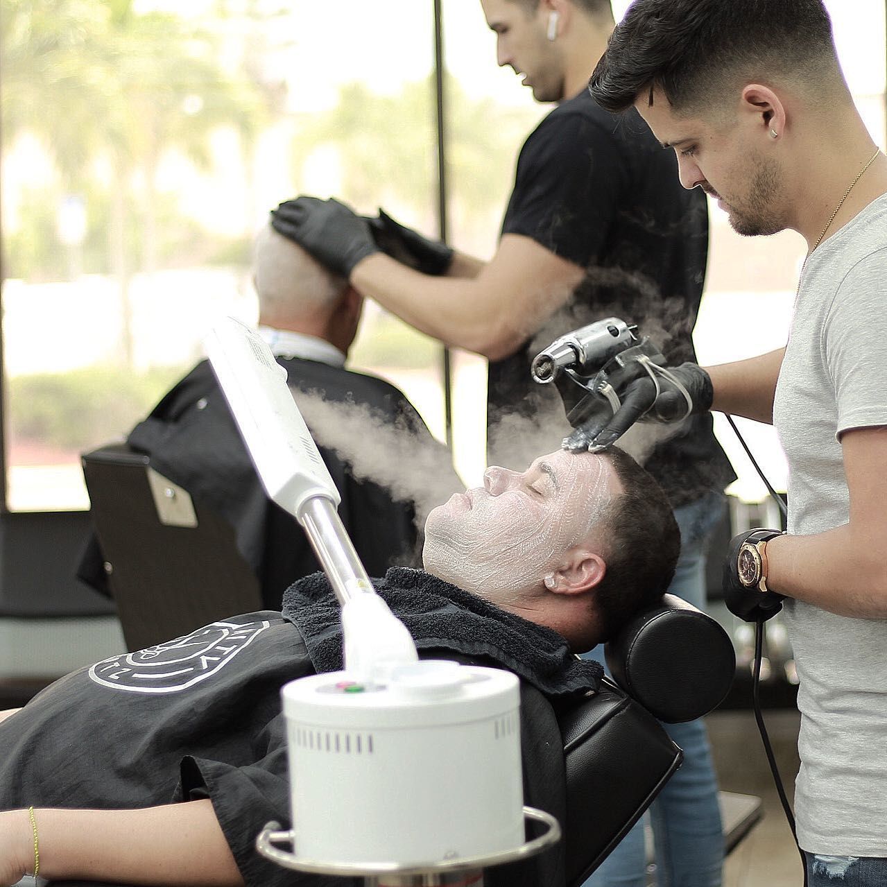 A man is getting his hair cut at a barber shop