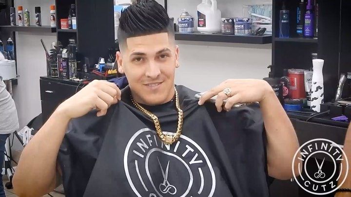A man is getting his hair cut at a barber shop.