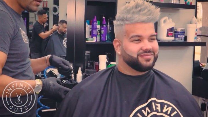 A man is getting his hair cut at a barber shop