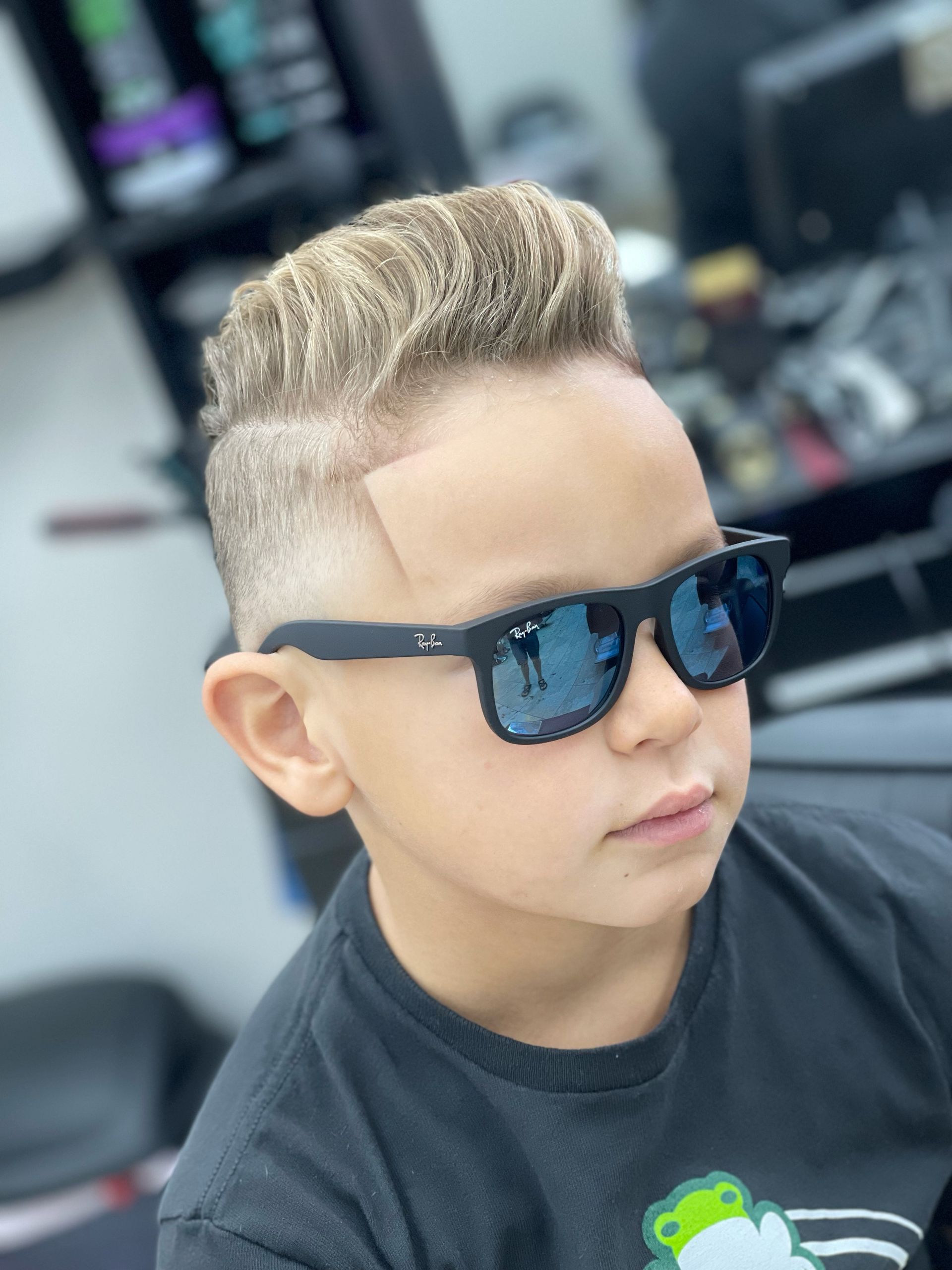 A young boy wearing sunglasses and a black shirt