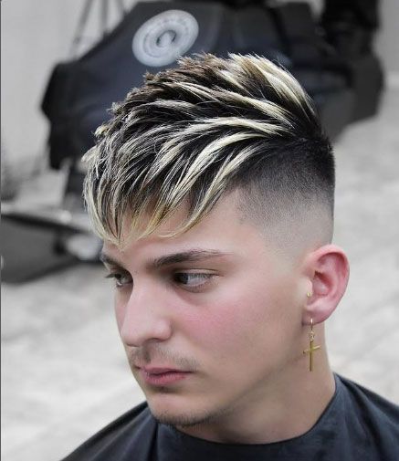 A man with a cross earring is getting his hair cut