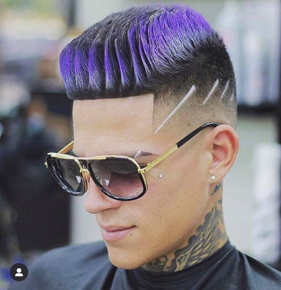 A man with purple hair is wearing sunglasses and a black shirt.
