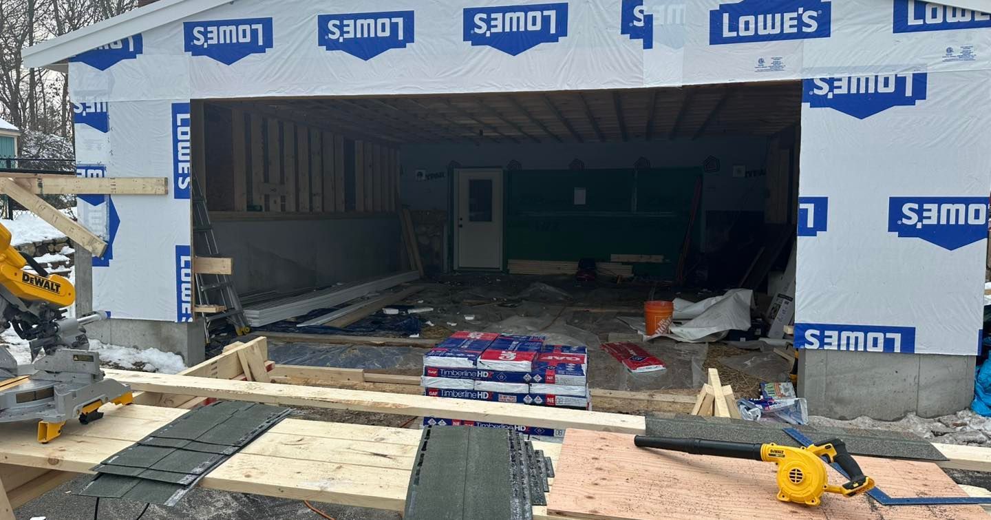 Lowe’s storefront under construction, with open entrance, building materials, and debris on the ground.