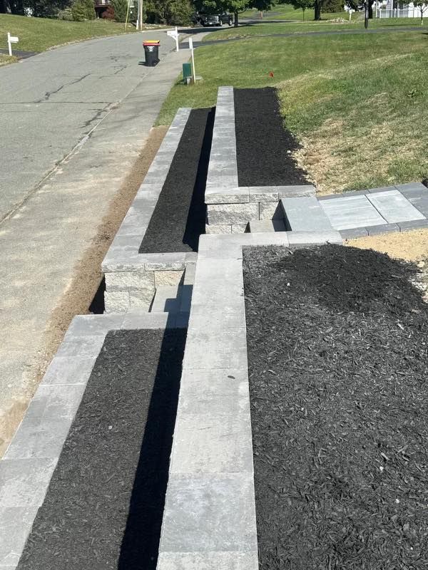 Curb ramp under construction beside a residential street, with concrete and black asphalt patches.