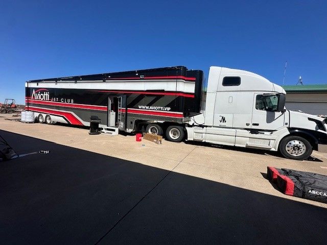 Hand holding a 3M wrap film color swatch book; various gloss and carbon fiber options.