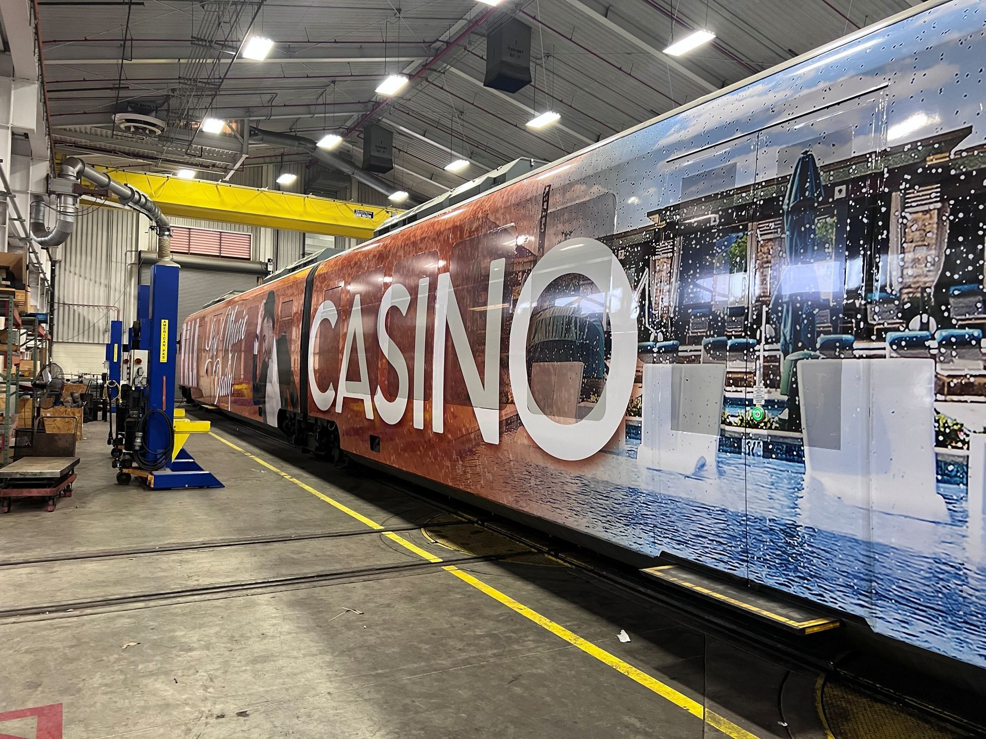 A casino-branded train car inside a maintenance facility. The car has large 