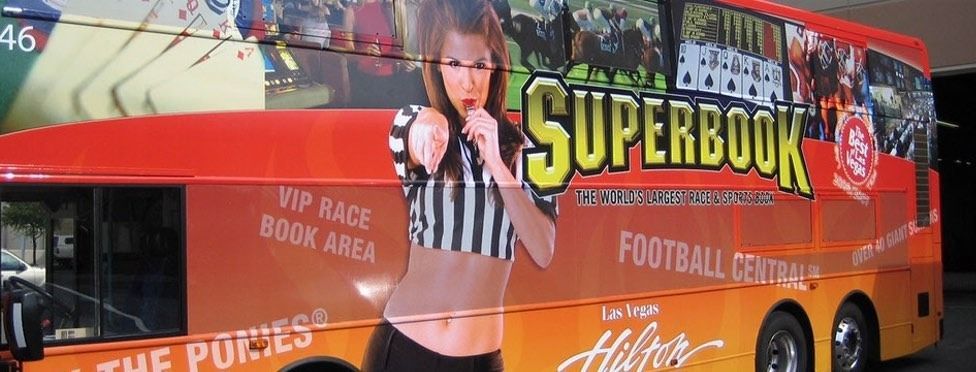 Bus with SuperBook advertisement. Woman in referee shirt. 