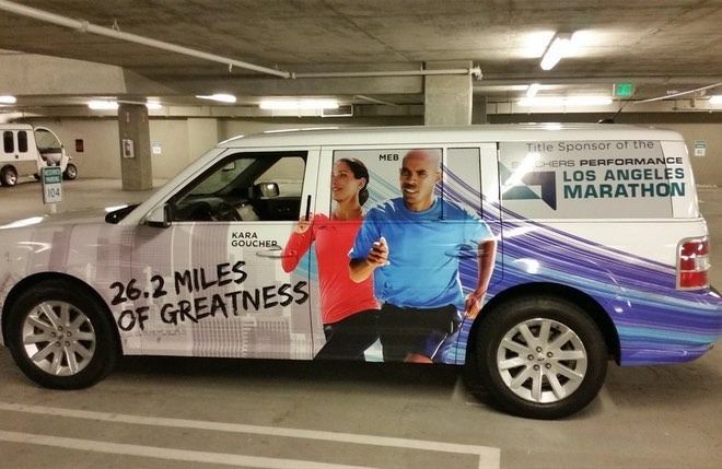 Car wrapped with a Los Angeles Marathon advertisement; a runner couple is featured.
