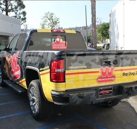 Truck with yellow and black Wiener'schnitzel branding. Big Dog 2 is on the side, with a logo in the back.