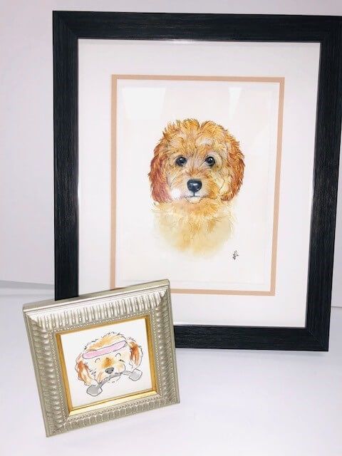 Watercolor portraits of a goldendoodle dog in a black frame, and a smaller sketch in a silver frame.