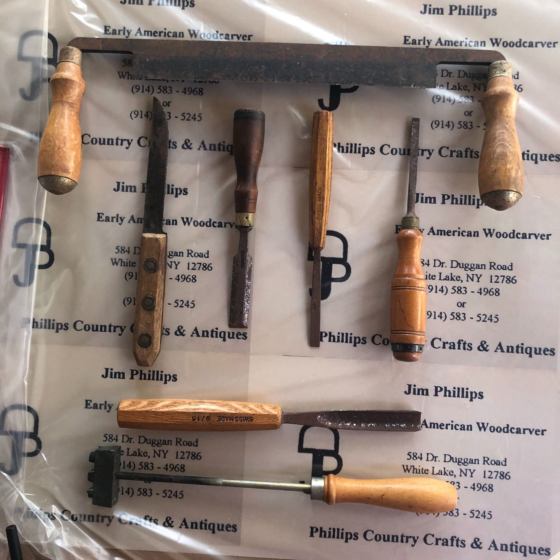 Collection of wood carving tools with wooden handles and metal blades, arranged on a surface.