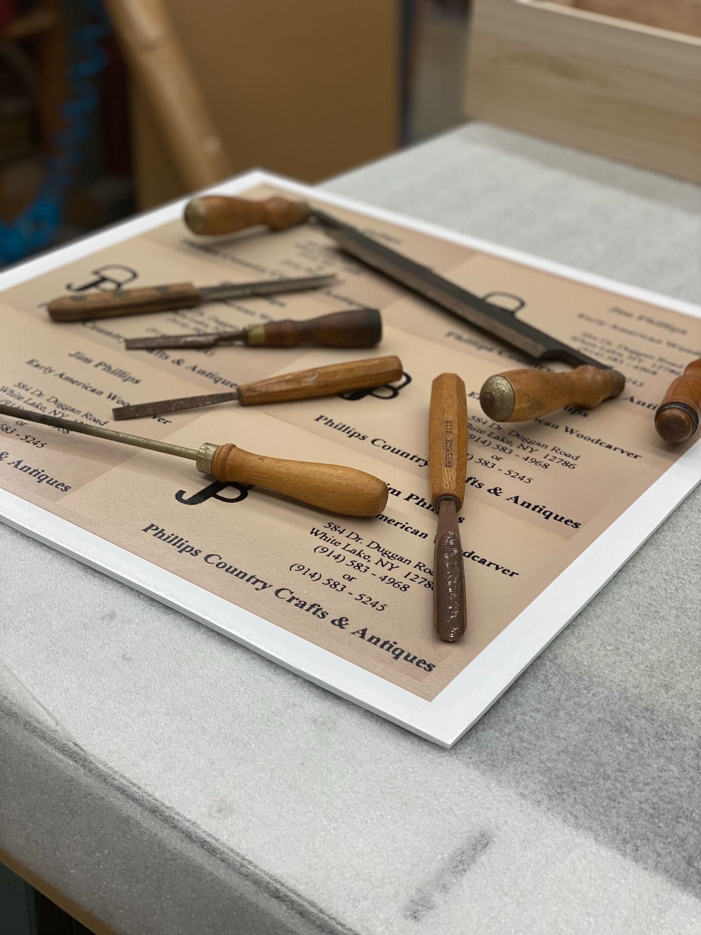 Wooden handled tools arranged on a display board, possibly for sale in an antique shop.