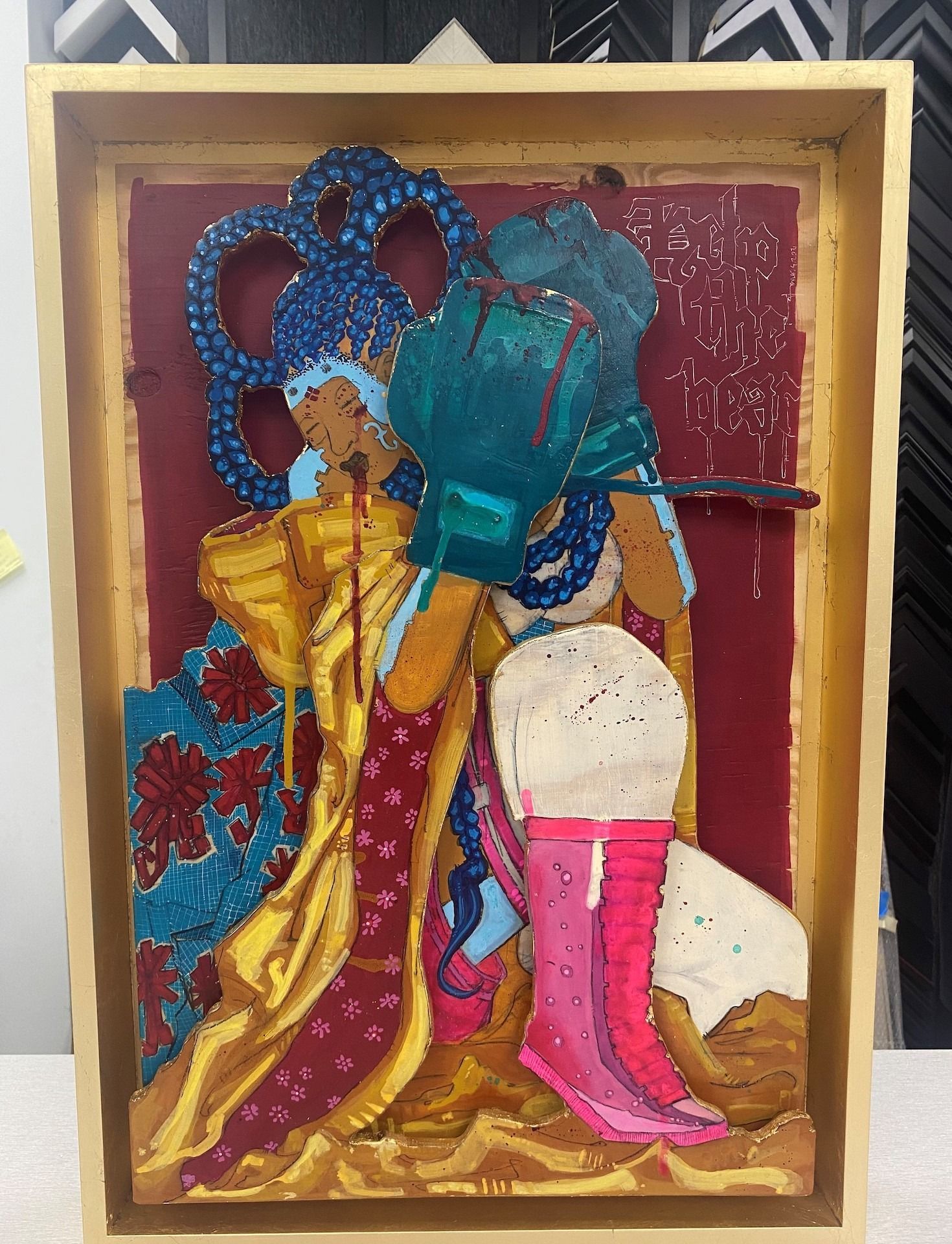 Colorful relief sculpture of a figure in blue hair and green gloves, with a pink boot, against a red backdrop.