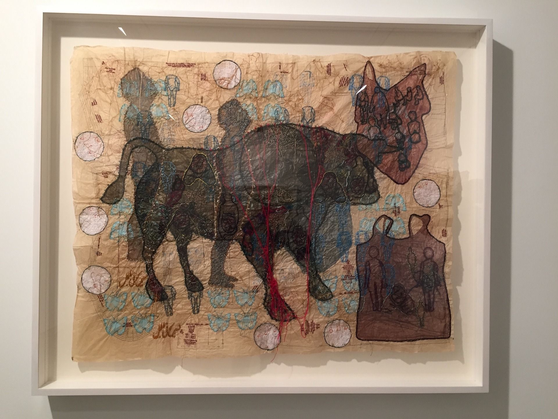 Artwork: Bull with figures, framed. Brown, black, and blue. Circles and floral elements surround the subject.