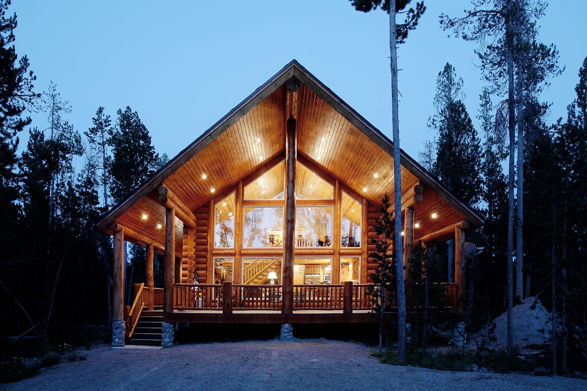 Cozy wooden cabin glowing warmly at dusk among tall trees