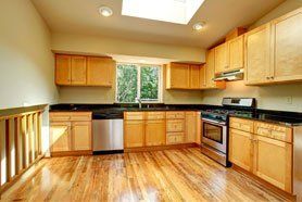 Spacious empty kitchen room with storage combination and steel appliances