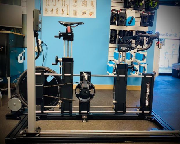 A bicycle is being adjusted on a machine in a store