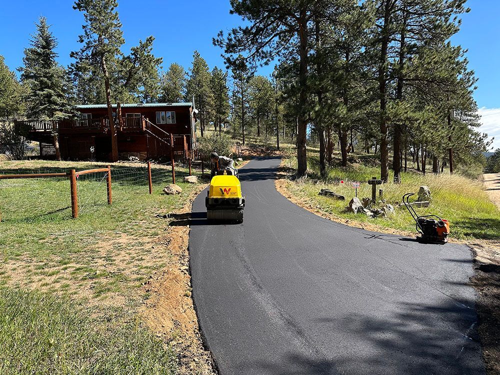 a yellow truck is driving down a road next to a house.
