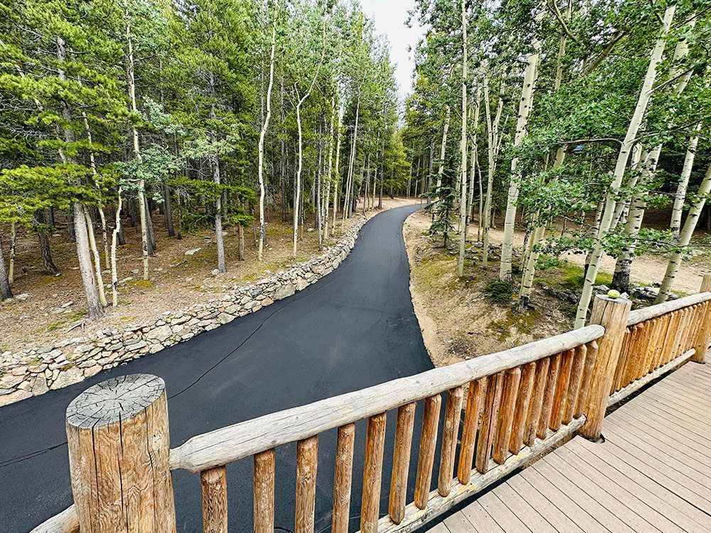 a wooden deck overlooking a curvy road in the woods.