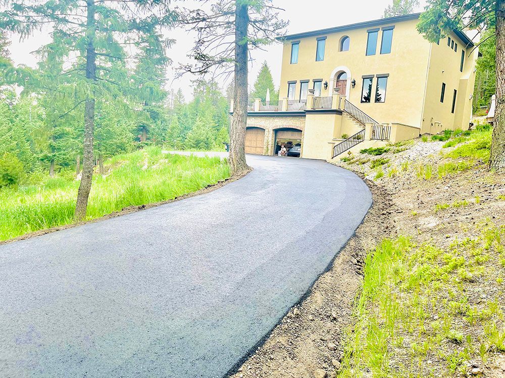 a large house is sitting on top of a hill next to a road.