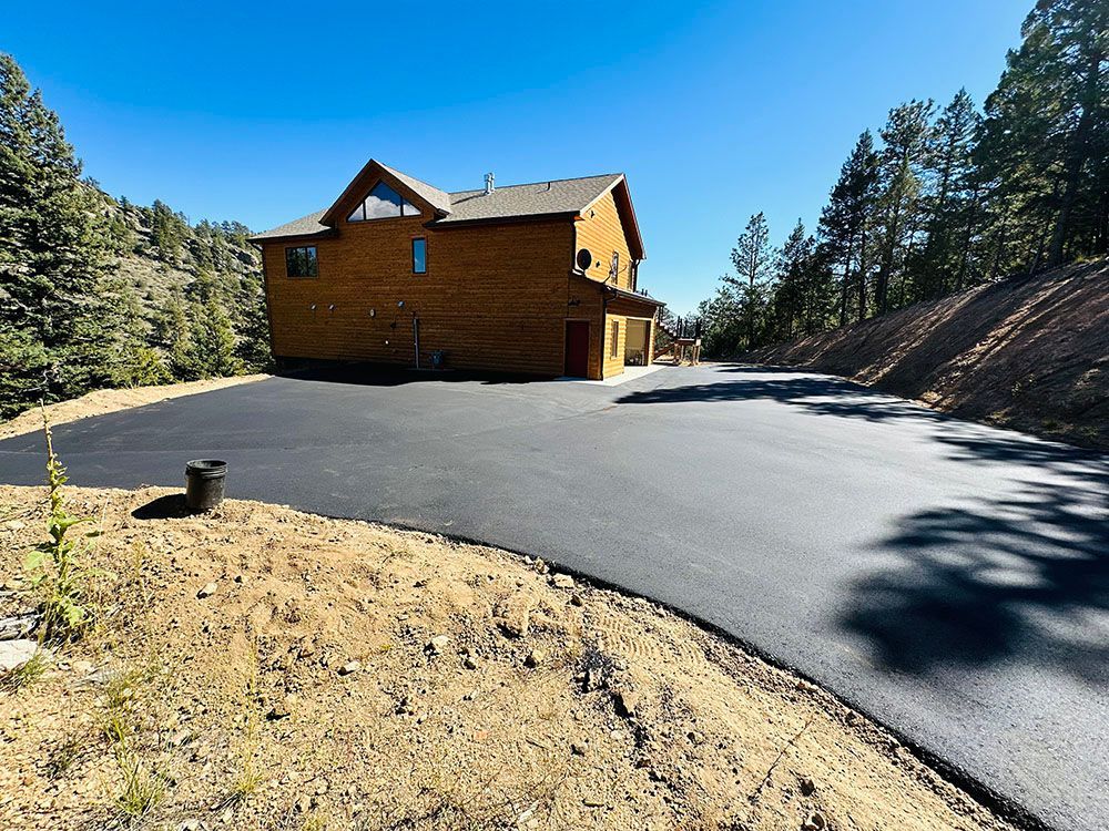 a large house is sitting on top of a hill next to a road.