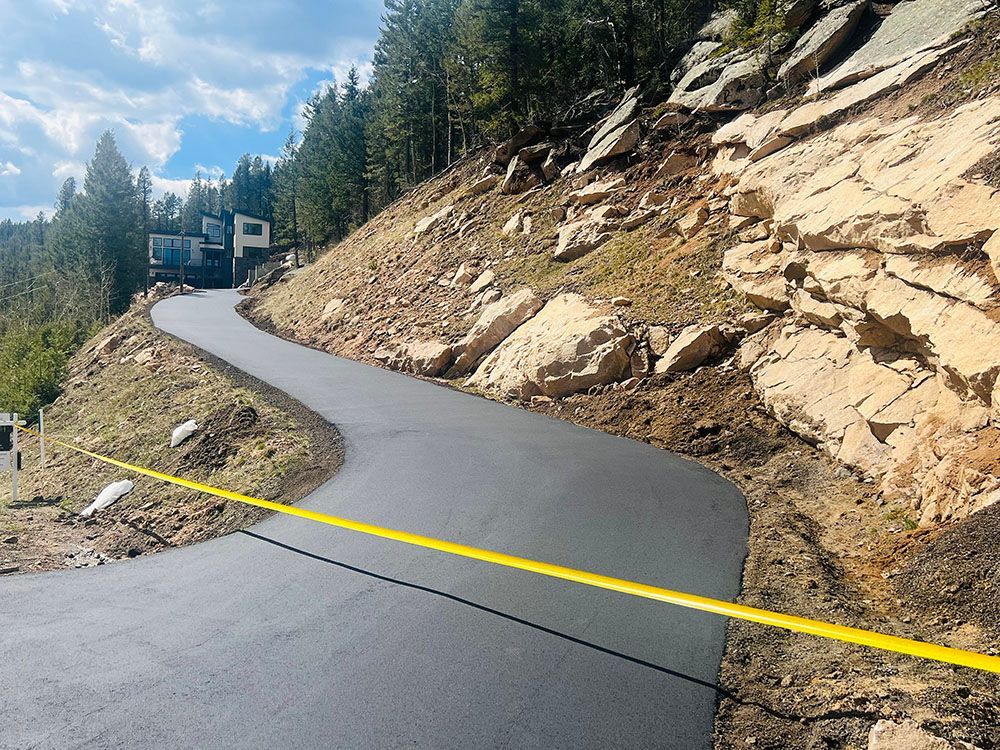 a road that is going up a hill with a house in the background.