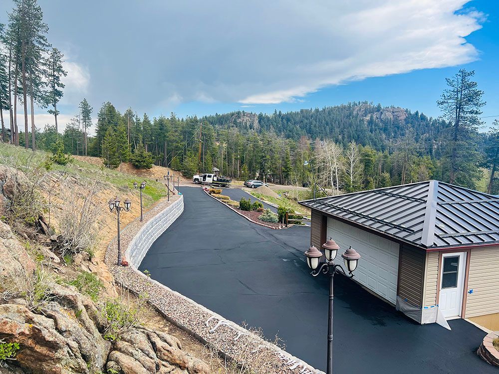 a house is sitting on top of a hill next to a road.