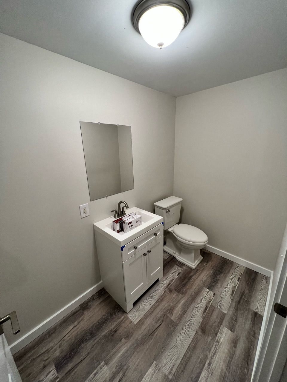 A bathroom with a sink , toilet and mirror.