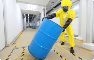 A man in yellow suit holding a metal container with chemical